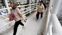 Sejumlah karyawan melintas di jembatan Busway.