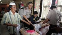 Seorang anak terus memegangi tangan orangtuanya saat tim dokter menyunat dirinya.
