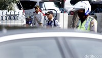 Petugas Dishubtrans dan personel polisi mengawasi pelat kendaraan yang melintas.