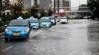 Sejumlah mobil berjalan pelan untuk menghindari genangan.