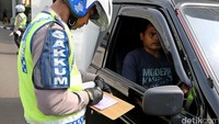 Polisi memberikan surat tilang kepada pengendara mobil berpelat ganjil.