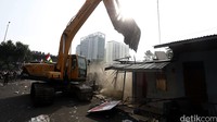 Satu per satu bangunan di pinggir rel kereta api itu dirobohkan oleh ekskavator.