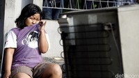 Seorang anak menangis sambil menatap rumahnya dirobohkan oleh ekskavator.
