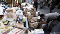 Barang-barang warga dikumpullan di pinggir jalan.