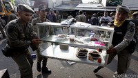 Satpol PP mengeluarkan barang-barang milik warga Rawajati.