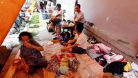 Seorang anak tertidur pulas di tenda darurat.