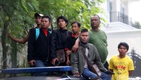 Warga menonton dari atas mobil.