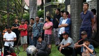 Warga menonton dari kejauhan karena sekitar lokasi telah dipasangi garis polisi.