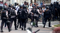 Puluhan polisi bersenjata lengkap dikerahkan untuk melumpuhkan dua pelaku perampokan dan penyanderaan.