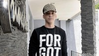 Ia tampak mengenakan Snapback coklat, kaus hitam, ripped jeans dan sandal. Pool/Noel/detikFoto.