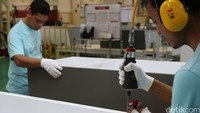 Pekerja tengah memasang mur dan baut-baut.