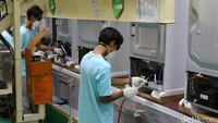 Para karyawan menyelesaikan proses pembuatan kulkas (refrigerator) LG.