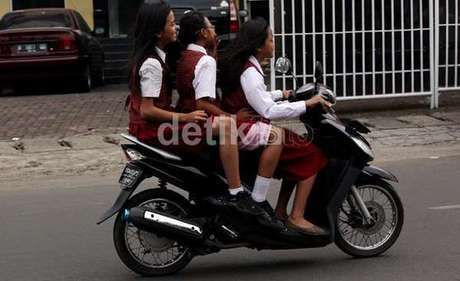 Anak di bawah umur berkendara di jalan raya. 
