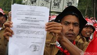 Seorang demonstran menunjukkan surat tuntutan aksi.
