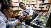 Petugas memeriksa obat yang dijual. Dalam penggeledahan ini, petugas menemukan obat kedaluwarsa di beberapa apotek.