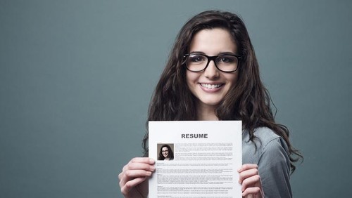 Young smiling cheerful woman holding her resume
