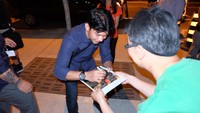 Iko Uwais memberikan tanda tangan kepada salah satu penggemar.