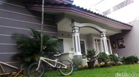 Ada sepeda yang terparkir halaman yang dihiasi aneka tanaman hias dan rumput hijau itu.