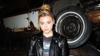 Ia tampil dengan jaket motor berbahan kulit dengan kaus dan rok mini berwarna hitam serta heels berwarna merah. Chance Yeh/Getty Images for Coach/detikFoto.