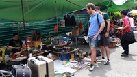 Dua orang turis tengah melihat-lihat barang di pasar loak atau Thieves Market.
