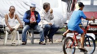Tiga orang warga berjaga di pintu masuk perumahan.