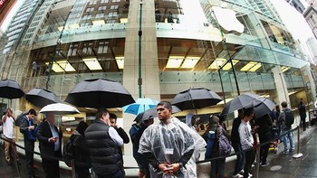 Meski sempat turun hujan tak menyurutkan minat fans Apple di Australia untuk membeli iPhone 7. Foto: Getty Images/Reuters