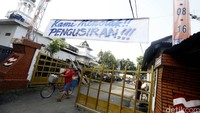 Warga memasang spanduk penolakan di gerbang masuk perumahan.