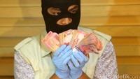 Petugas KPK menunjukkan barang bukti uang pecahan Rp 100 ribu.