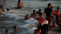 Foto: Mereka bermain air dengan sangat gembira. Berenang, dan berkejaran dengan ombak. Pantai menjadi oase hiburan di tengah konflik di  Gaza (Nidal Al Mughrabi/Reuters)