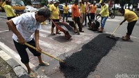 Petugas Bina Marga Jakarta Timur pun turun menambal jalan-jalan yang berlubang, Senin (19/9).