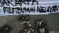 Ikan yang mereka bawa diletakkan di depan spanduk menolak reklamasi Teluk Jakarta.