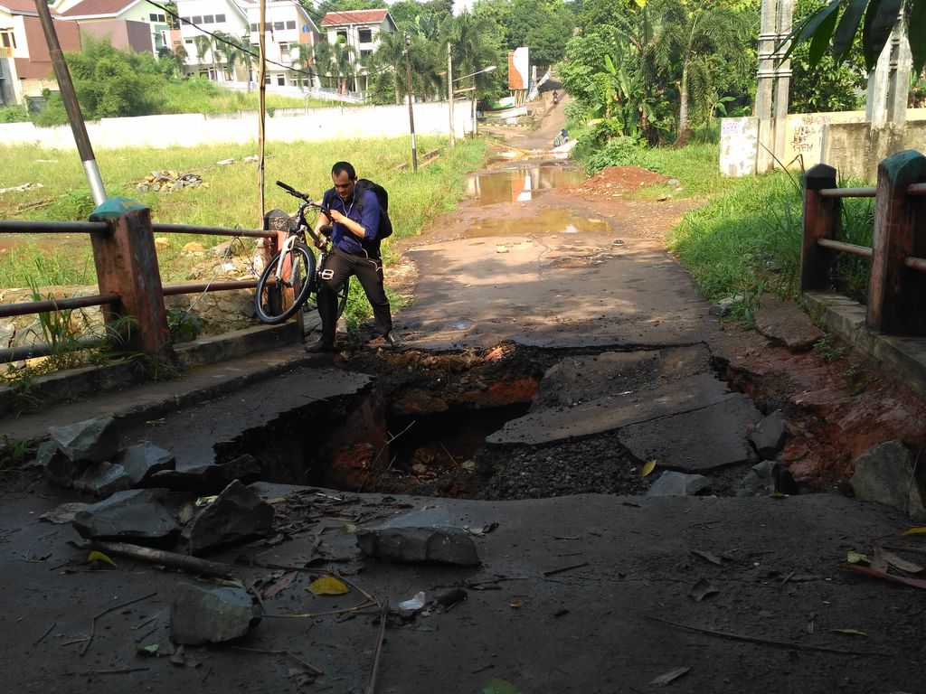 Warga menenteng sepeda melewati jembatan yang jebol (Bartanius Dony/detikcom)