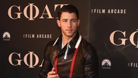 Ia tampil dengan jaket hitam dengan aksen merah dan putih, celana panjang dan sneakers hitam. Theo Wargo/Getty Images/detikFoto.
