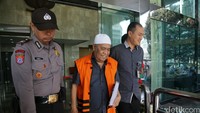 Zulkifli Effendi Siregar berjalan menuju mobil tahanan dengan dikawal polisi.