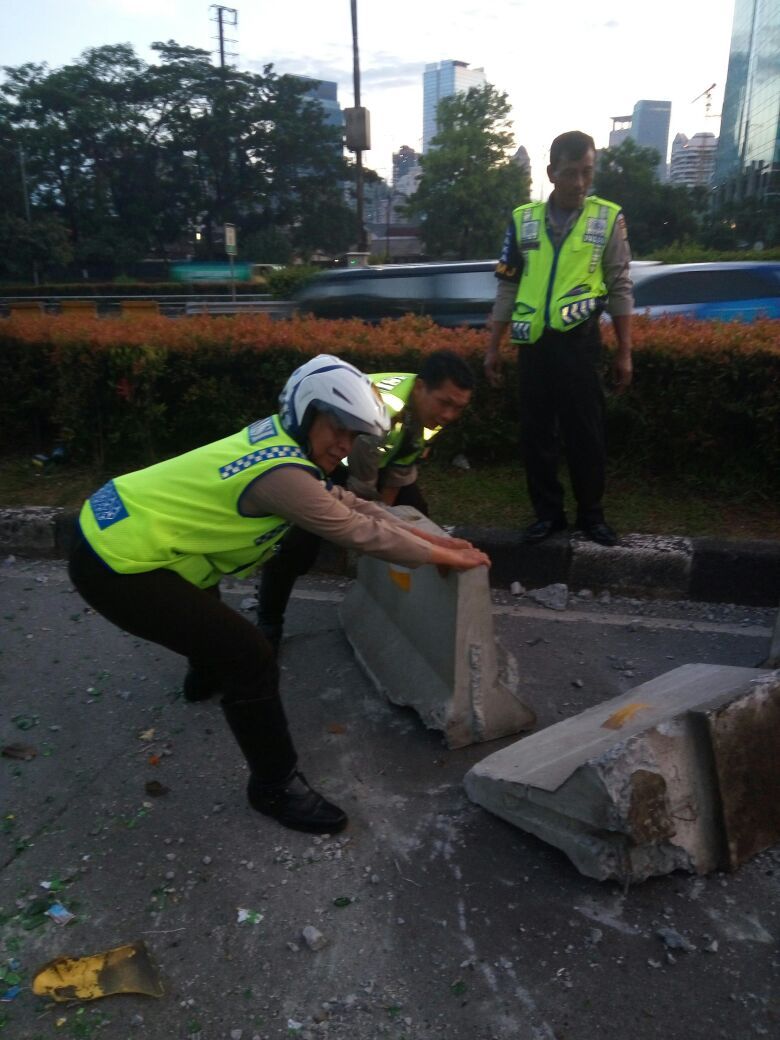 Polisi berupaya menyingkirkan separator busway yang hancur ditabrak truk ini  (@TMCPoldaMetro)