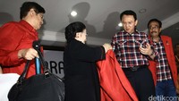 Ahok tampak kikuk namun mau saja memakai jas merah tersebut.
