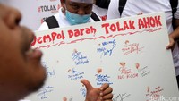 Massa membubuhkan cap jempol darah menolak Ahok di sebuah kain.