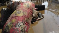 Barang-barang yang terbawa banjir masih bergeletakan di jalan.