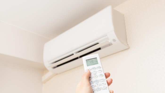 air conditioner Young Beautiful Woman Opening Air Conditioner At Home