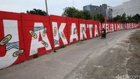 Pernyataan keras mural Jakarta Kelebihan Beban di bantaran Kali Opak, Penjaringan.