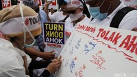 Seorang pendemo membubuhkan cap jempol darah.