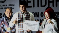 Agus terlihat mengenakan kemeja putih lengkap dengan kopiah dan mengalungkan sarung, nampak serasi dengan Sylviana yang mengenakan baju senada dengan kerudung putih.