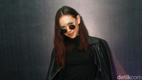 Ia tampil dengan jaket dan kaus hitam serta celan panjang biru bermotif garis dan heels hitam. Pool/Gus Mun/detikFoto.