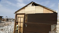 Seorang anak bermain di depan rumah semi permanen yang didirikan warga.