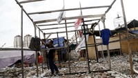 Seorang warga menjemur pakaian di rangka bangunan yang mereka dirikan di Kampung Akuarium.