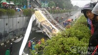 Jembatan roboh bersamaan dengan hujan deras dan angin kencang.