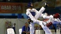 Atlet taekwondo Kalimantan Utara Chaerul Adzan (biru) saling serang dengan atlet tuan rumah.