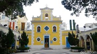 Kapel St Francis Xavier beralamat di Rua do Caetano, Largo Eduardo Marques, Coloane, Macau. Dilihat dari depan, kapel tampak cantik dengan cat kuning cerah, daun pintu berwarna biru dan jendela oval (Kurnia/detikTravel)