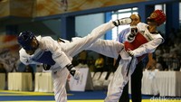 Atlet taekwondo Kalimantan Utara Chaerul Adzan (biru) melepaskan tendangan ke arah lawan.