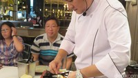 Chef Chandra membentuk adonan sate lilit menjadi quenelle dengan bantuan sendok.